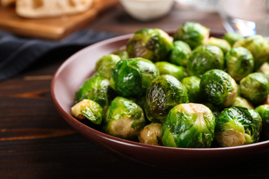 Photo of Delicious roasted Brussels sprouts on wooden table