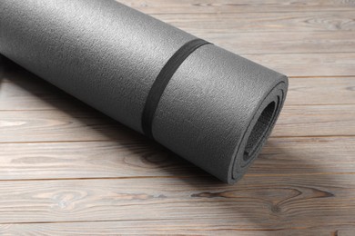 Photo of One grey yoga mat on wooden floor