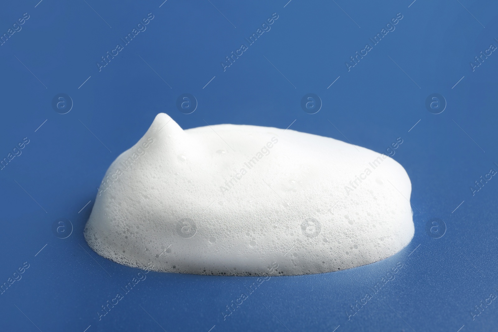 Photo of Drop of soap foam on color background