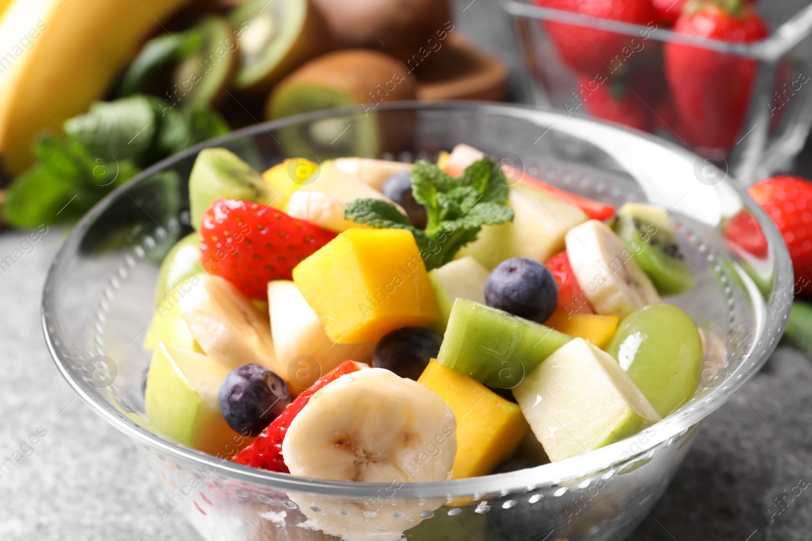 Photo of Delicious fresh fruit salad in bowl on table, closeup