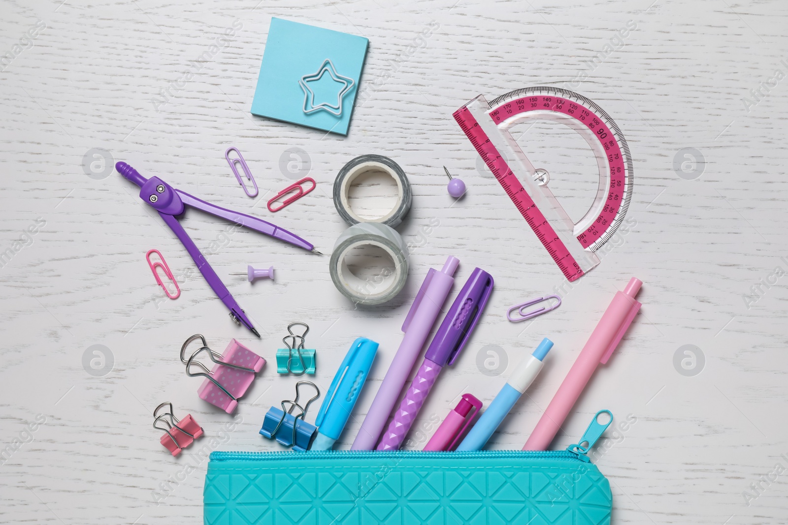 Photo of Different school stationery and pencil case on white wooden table, flat lay