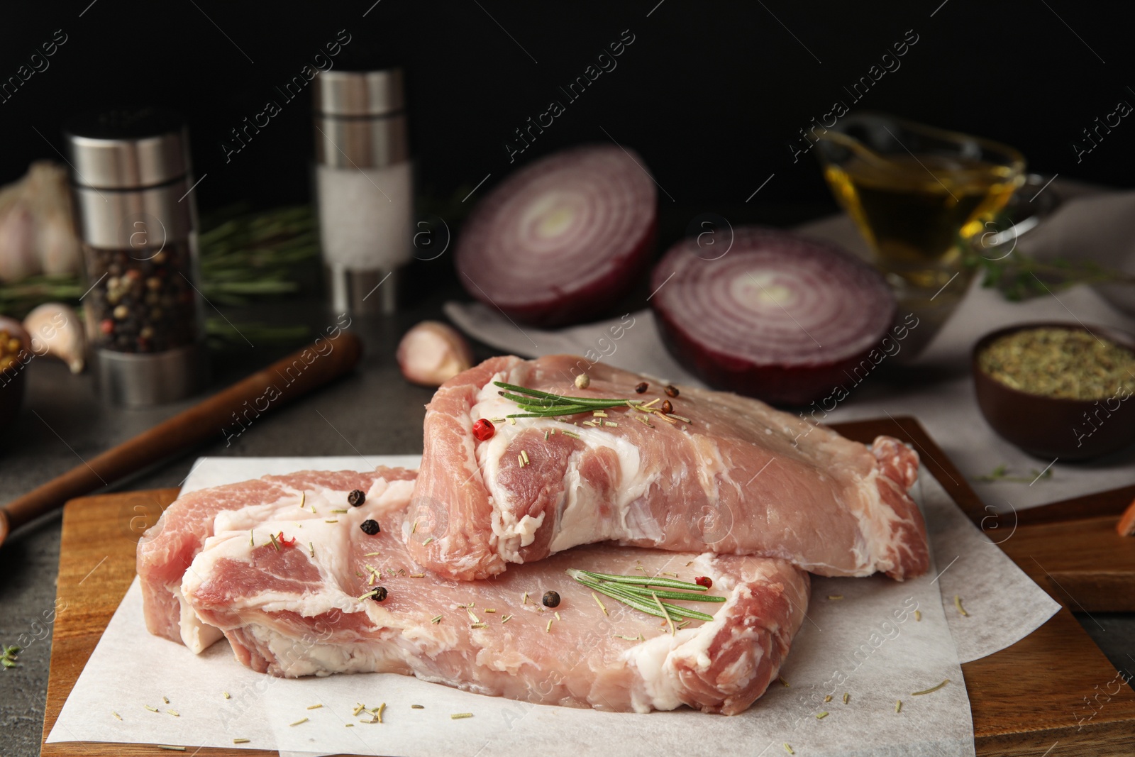 Photo of Fresh raw beef cut with rosemary and peppers mix on table