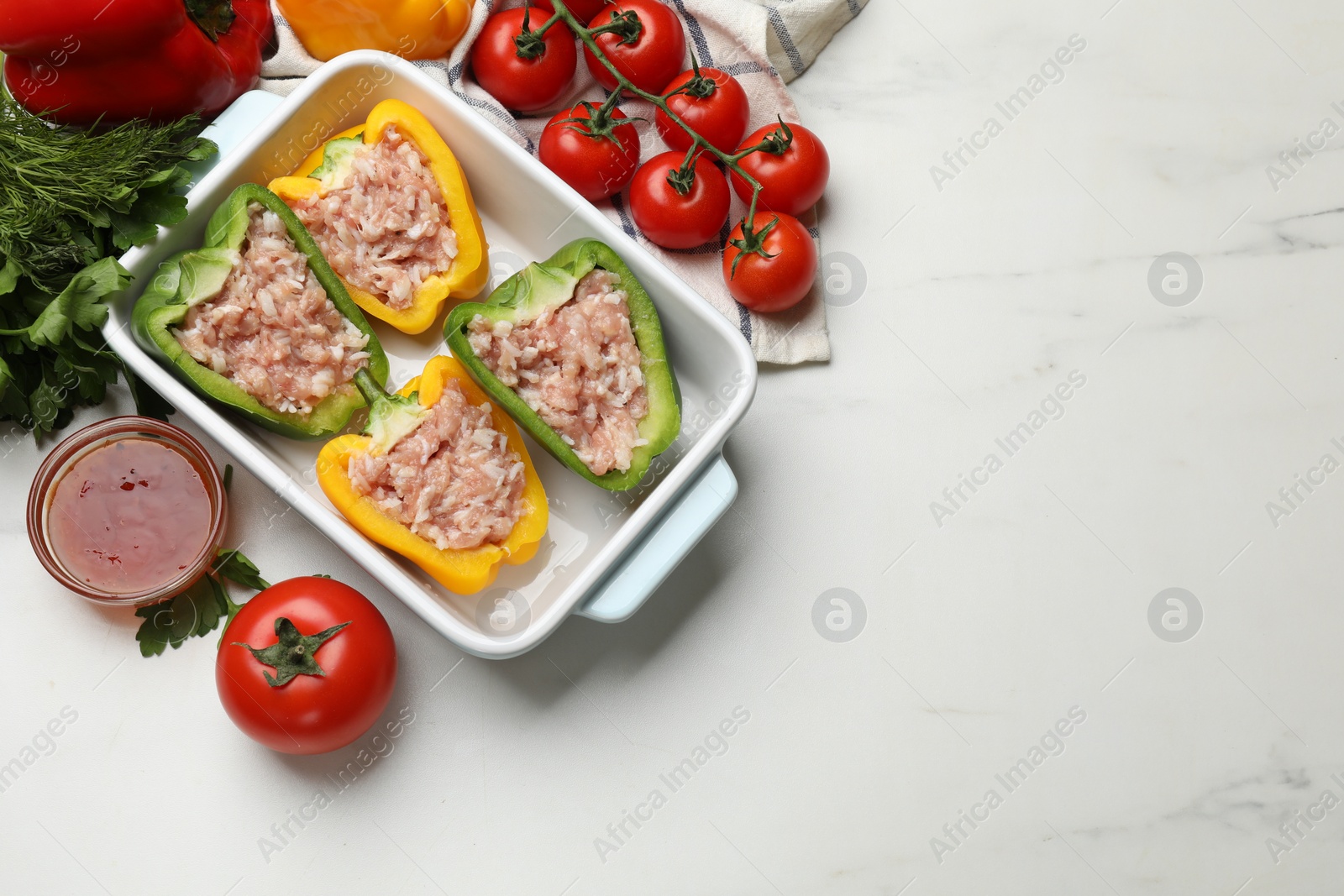 Photo of Raw stuffed peppers and ingredients on white table, flat lay. Space for text