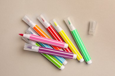 Photo of Many bright markers on light grey background, flat lay