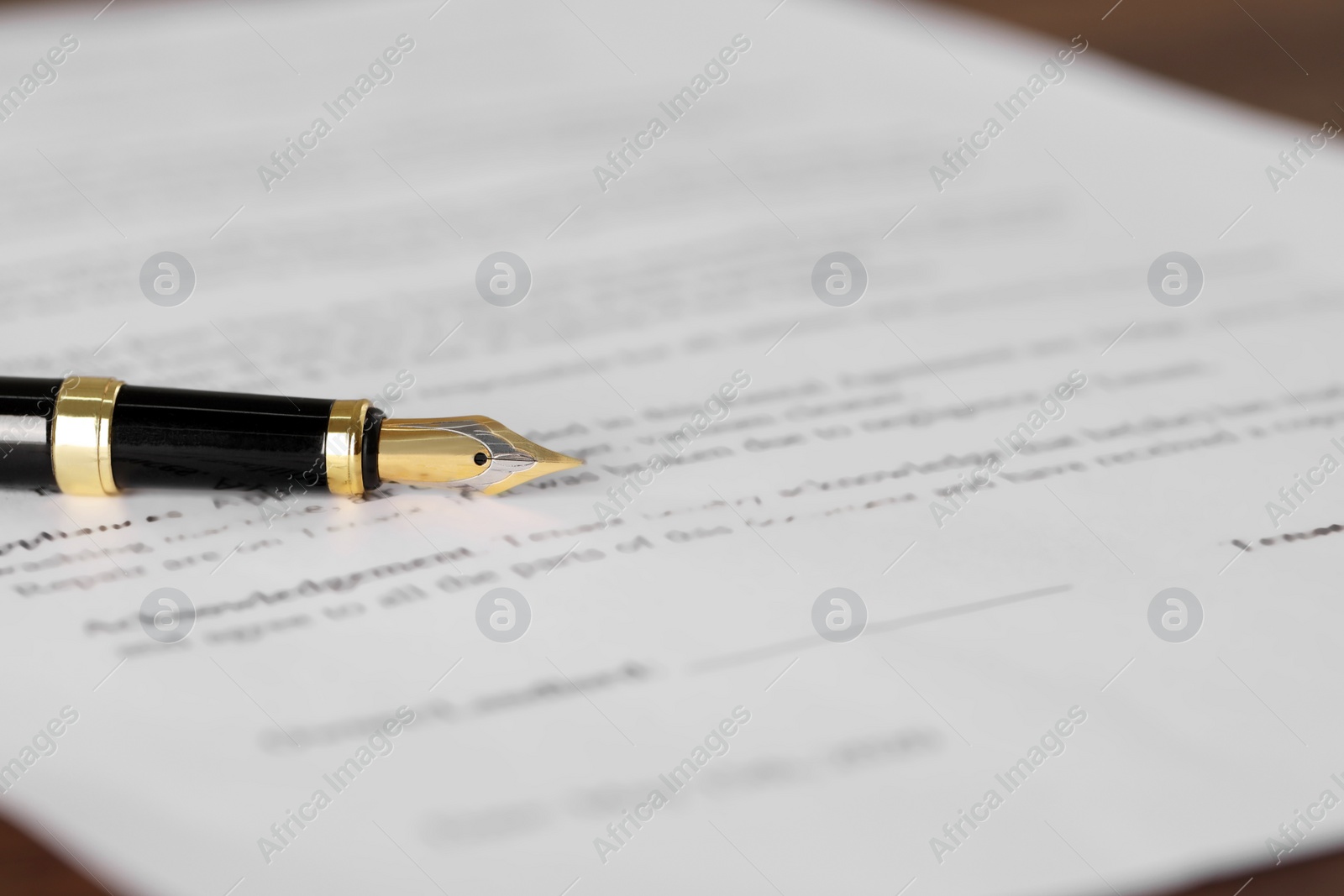 Photo of Fountain pen on document, closeup and space for text. Notary contract