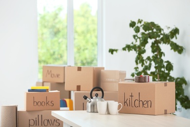 Photo of Cardboard boxes and household stuff indoors. Moving day