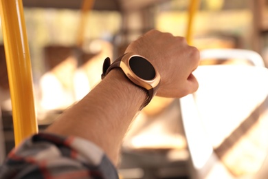 Photo of Man with smart watch in bus, closeup