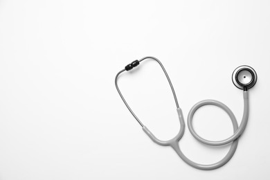Photo of Stethoscope on white background, top view. Space for text