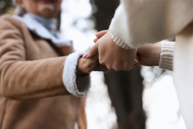 Trust and support. Women joining hands outdoors, low angle view