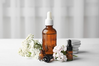 Photo of Composition with essential oils and flowers on table