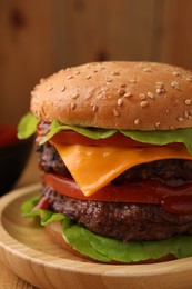 Photo of Tasty cheeseburger with patties and tomato on table, closeup