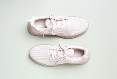 Stylish sporty sneakers on light background, top view