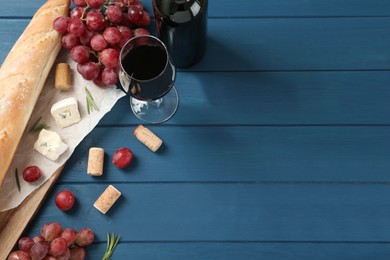 Photo of Flat lay composition with red wine and snacks on blue wooden table, space for text