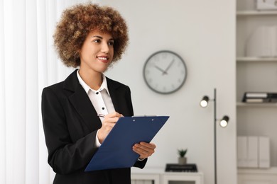 Photo of Happy notary with clipboard writing notes in office