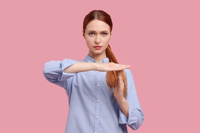 Photo of Woman showing time out gesture on pink background