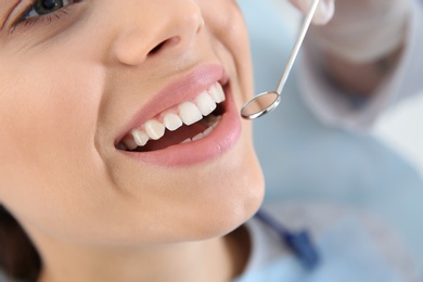 Photo of Dentist examining patient's teeth in modern clinic, closeup