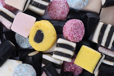 Photo of Many tasty liquorice candies on white background, top view