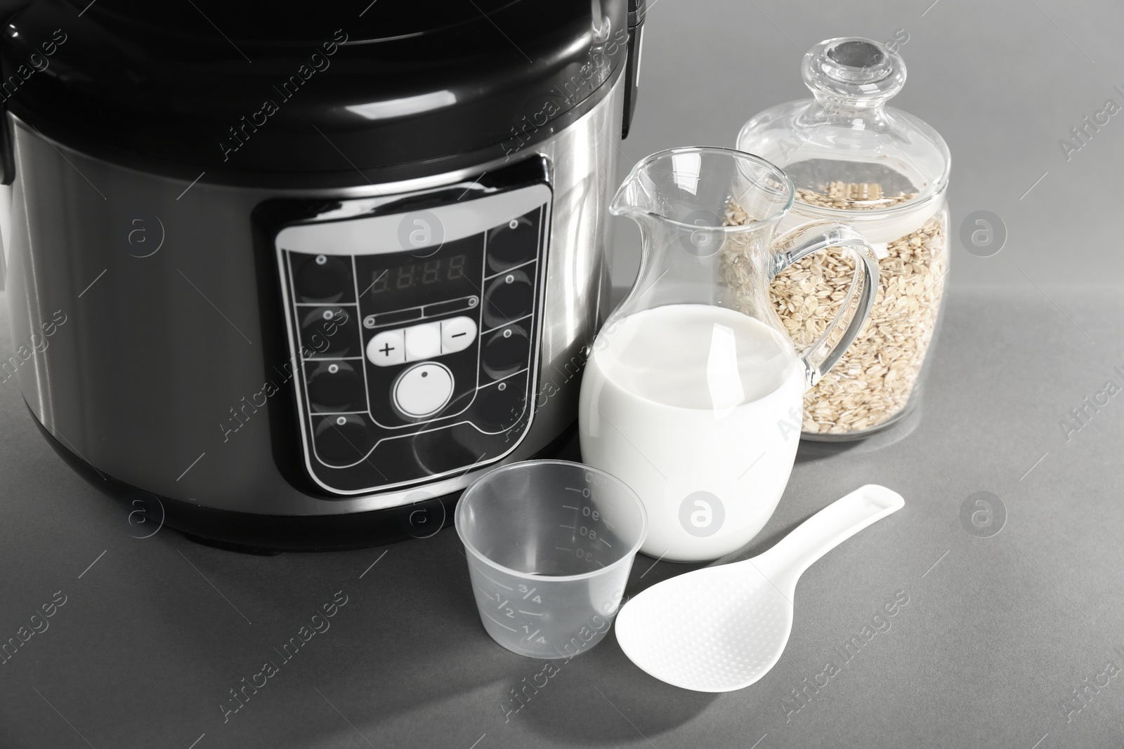 Photo of Modern powerful multi cooker and products on grey table