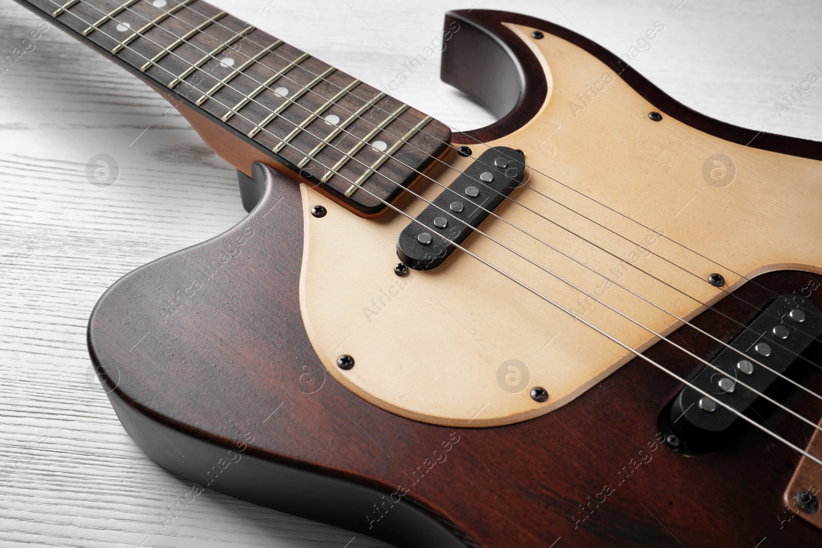 Photo of Modern electric guitar on wooden background. Musical instrument