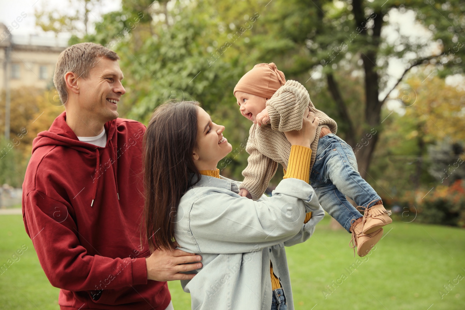 Photo of Happy parents with their adorable baby walking in park