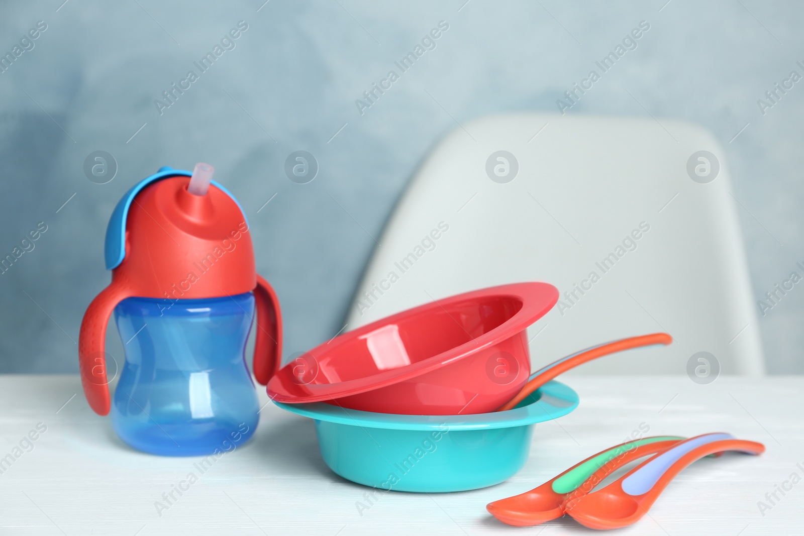 Photo of Set of plastic dishware on white table. Serving baby food