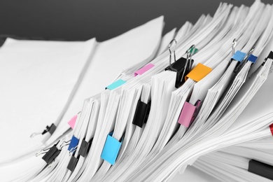Pile of documents with colorful binder clips, closeup
