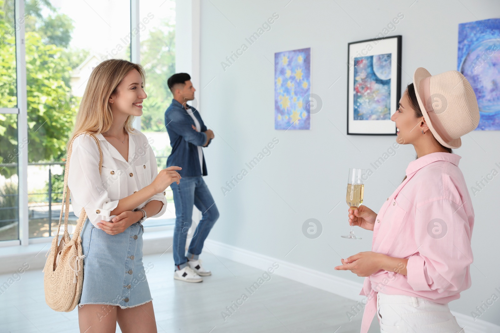 Photo of Young women at exhibition in art gallery