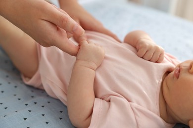 Photo of Mother with her cute little baby in crib, closeup