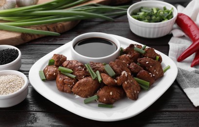 Tasty soy sauce and roasted meat on wooden table