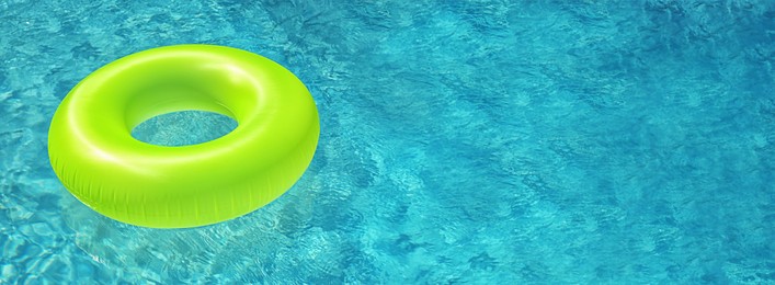 Image of Bright inflatable ring floating in swimming pool on sunny day, space for text. Banner design