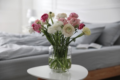 Photo of Bouquet of beautiful ranunculuses on table in bedroom