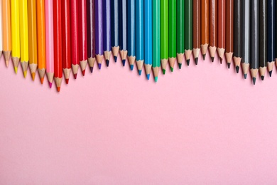 Photo of Color pencils on pink background, flat lay. Space for text