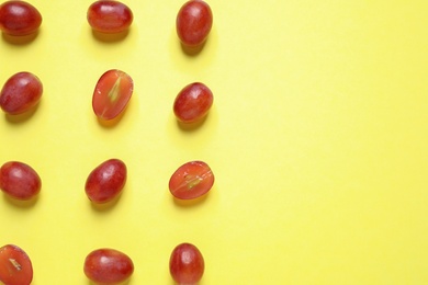 Photo of Flat lay composition with fresh ripe juicy grapes on yellow background, space for text