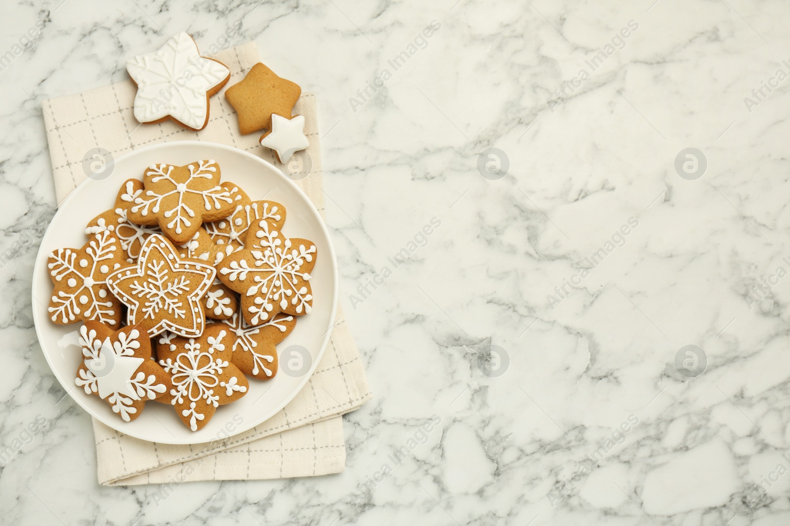 Photo of Tasty star shaped Christmas cookies with icing on white marble table, top view. Space for text