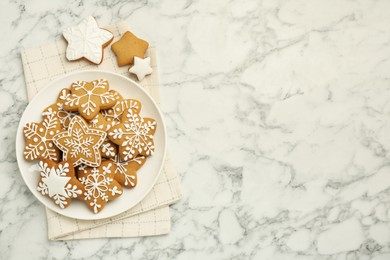 Tasty star shaped Christmas cookies with icing on white marble table, top view. Space for text