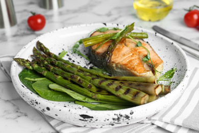 Tasty salmon steak served with grilled asparagus on plate