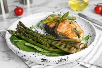 Photo of Tasty salmon steak served with grilled asparagus on plate