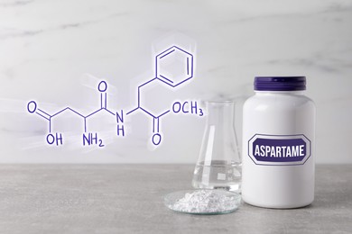 Image of Chemical structural formula of aspartame. Artificial sweetener in petri dish and bottle on gray table