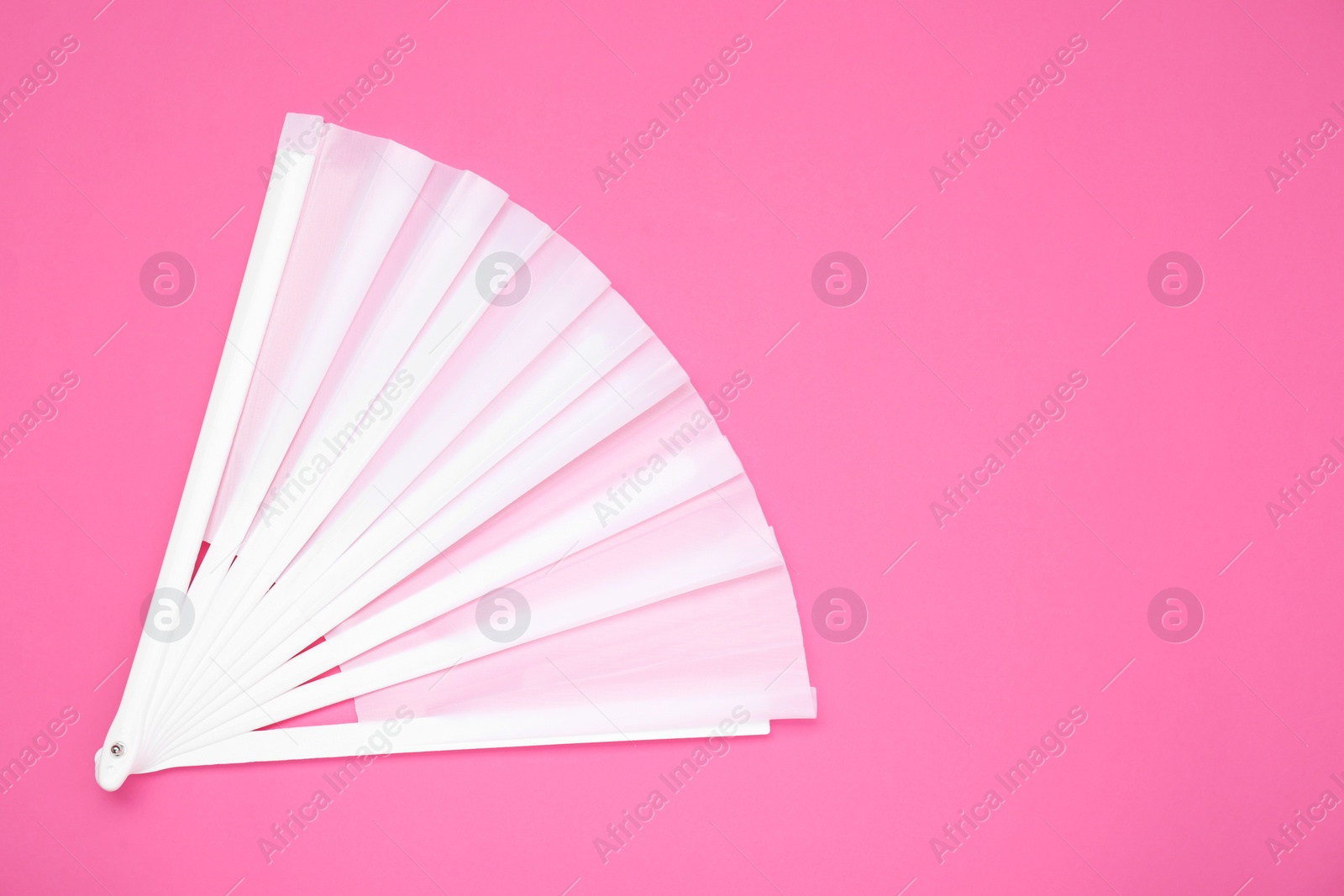 Photo of Stylish white hand fan on pink background, top view. Space for text