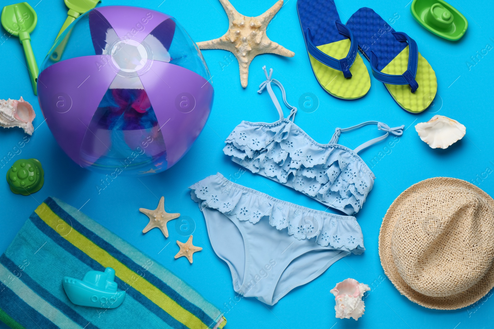 Photo of Flat lay composition with beach ball and sand toys on light blue background, space for text