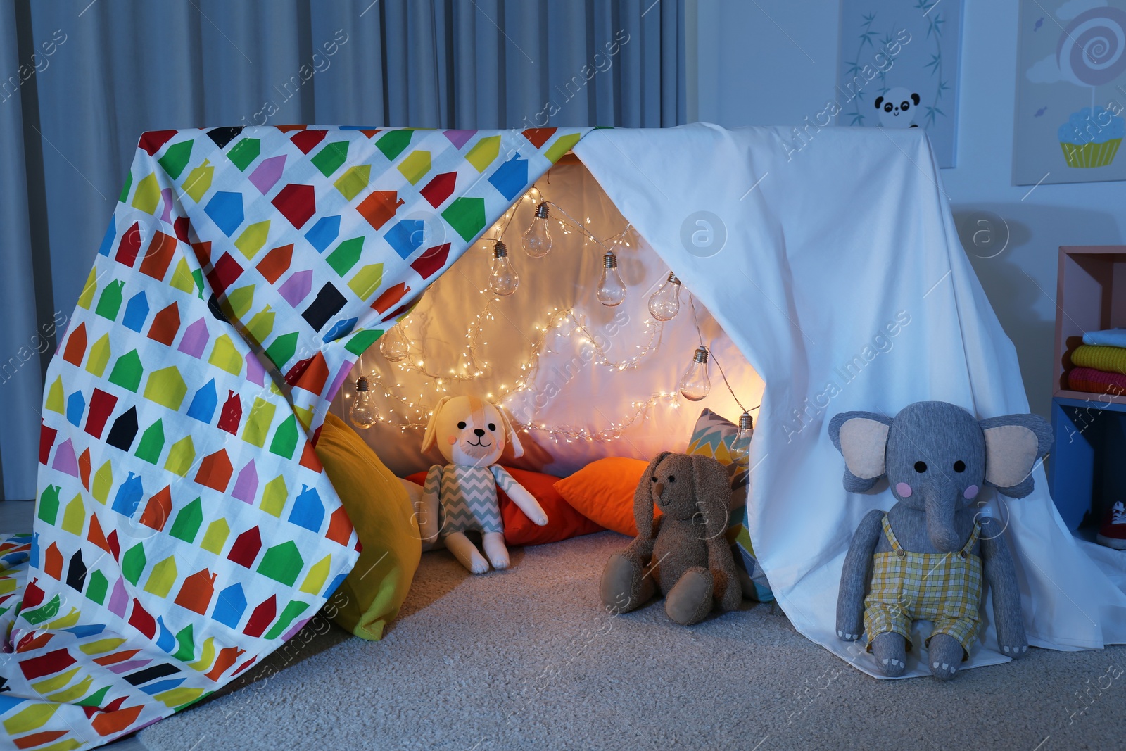 Photo of Play tent decorated with festive lights in modern child's room