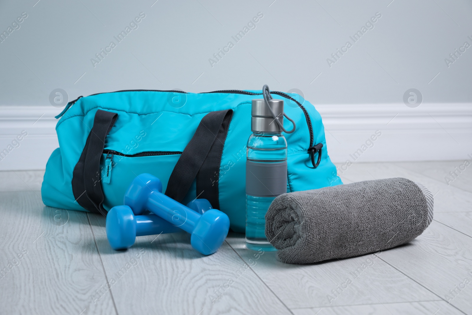 Photo of Bag with different sports equipment on wooden floor indoors