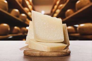Image of Delicious parmesan cheese on wooden table in warehouse
