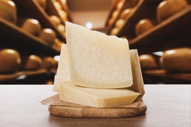 Delicious parmesan cheese on wooden table in warehouse