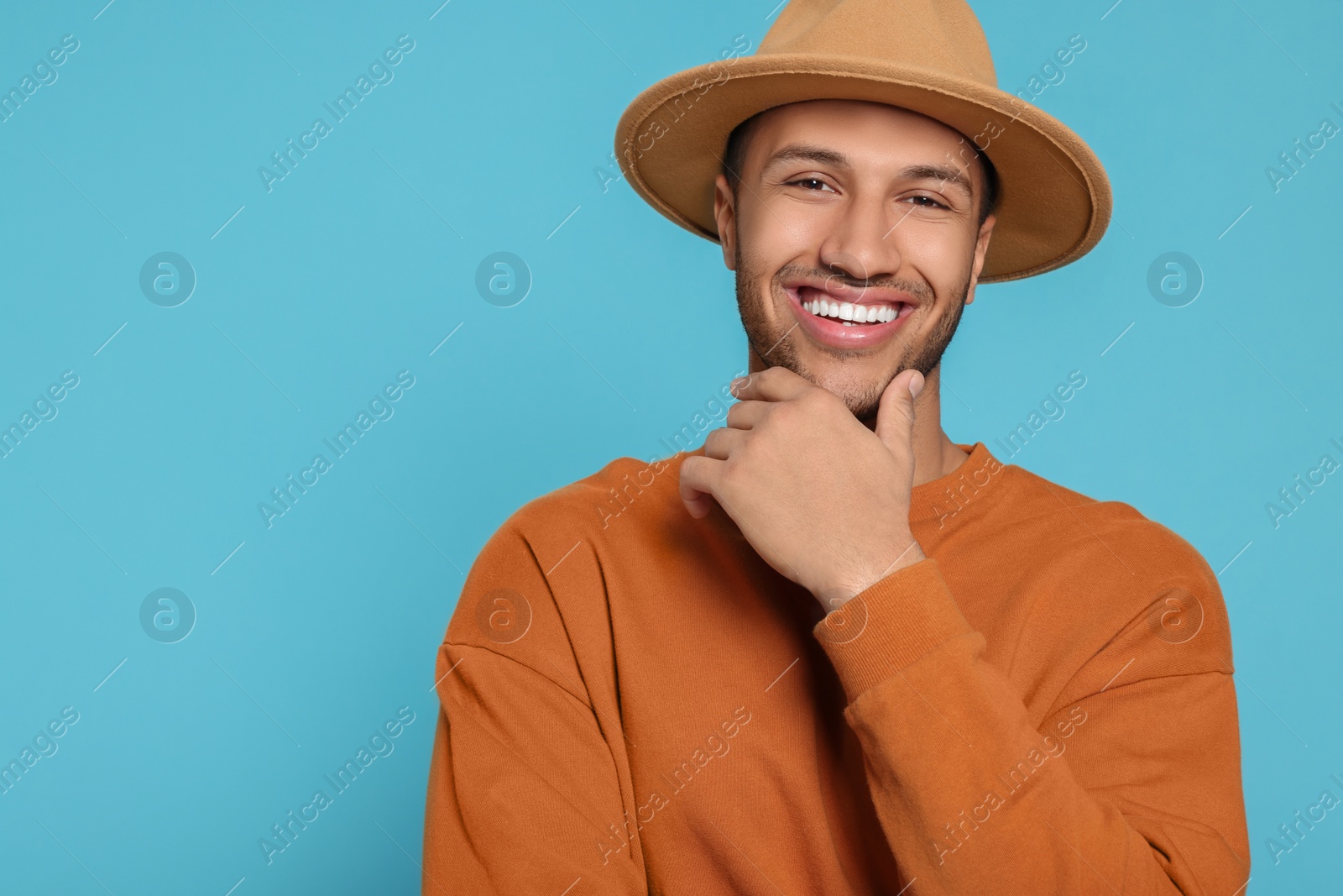 Photo of Portrait of happy African American man on light blue background. Space for text