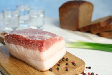 Photo of Composition with pork fatback on white table. Space for text