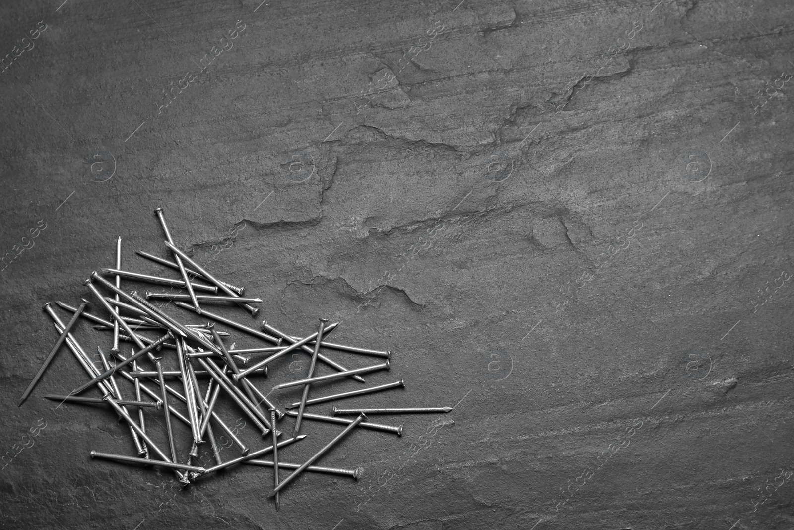 Photo of Many metal nails on grey background, flat lay. Space for text