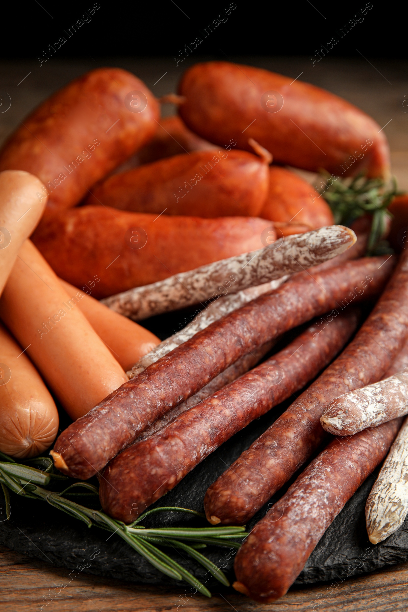 Photo of Different tasty sausages on wooden table, closeup