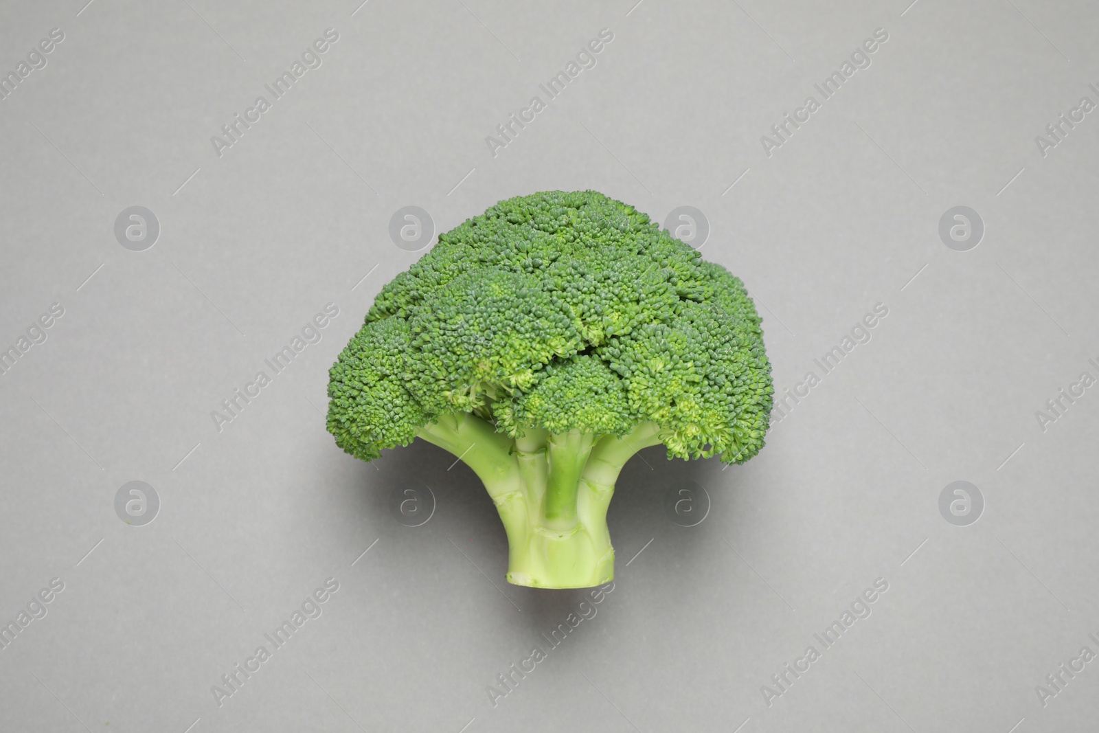 Photo of Fresh tasty broccoli on grey background, top view