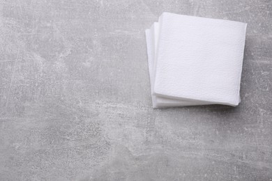 Photo of Stack of clean paper tissues on light grey background, top view. Space for text